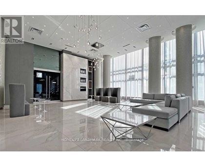 A modern living room with a glass table and grey sofas.