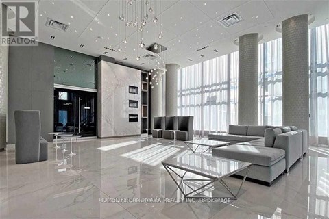 A modern living room with a glass table and grey sofas.