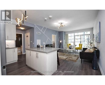 A modern kitchen with a large island and a dining area with yellow chairs.