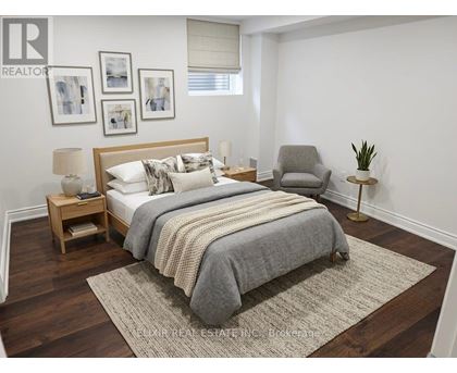 A bedroom with a large bed, a nightstand, a chair, and a rug.