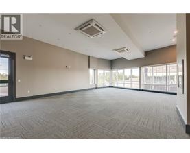A spacious room with a carpeted floor and large windows.