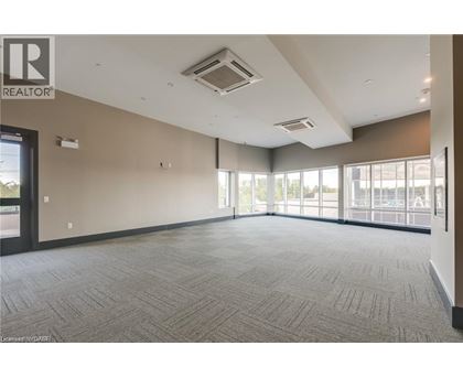 A spacious room with a carpeted floor and large windows.