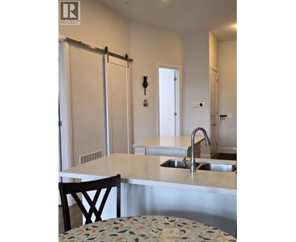 A kitchen with a sink and a chair.