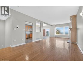 A spacious room with wooden flooring and a large window.