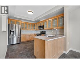 A kitchen with wooden cabinets and a stainless steel refrigerator.