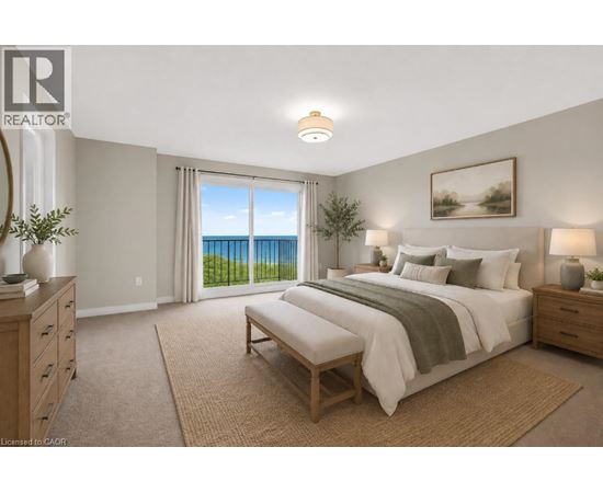 A bedroom with a large bed and a view of the ocean through the window.