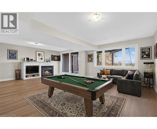 A pool table is in the middle of a living room.