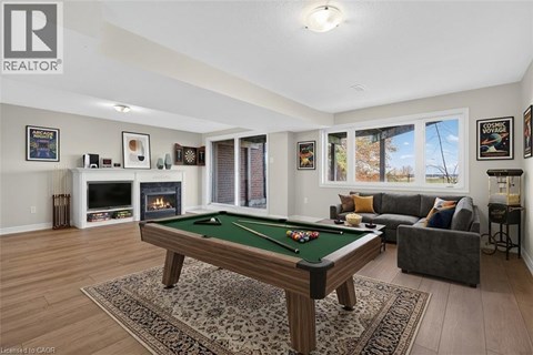 A pool table is in the middle of a living room.