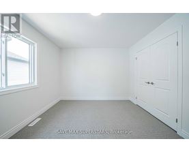 A white bedroom with a door and a window.