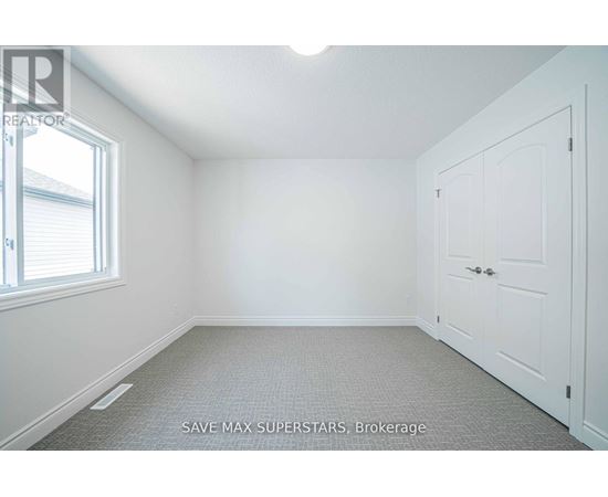 A white bedroom with a door and a window.