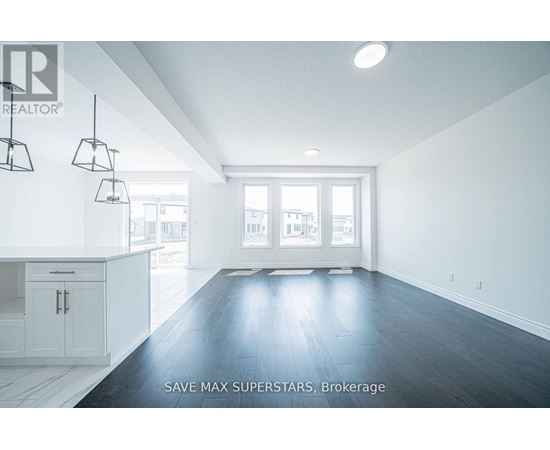 A spacious room with a kitchen area and a large window.