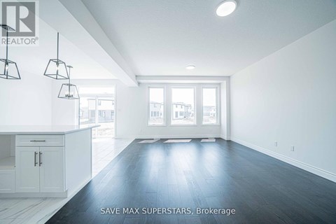 A spacious room with a kitchen area and a large window.