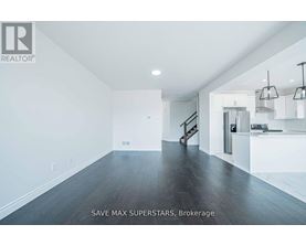 A spacious room with a staircase leading to the second floor.