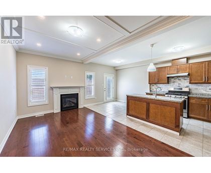 A spacious living room with hardwood floors and a fireplace.