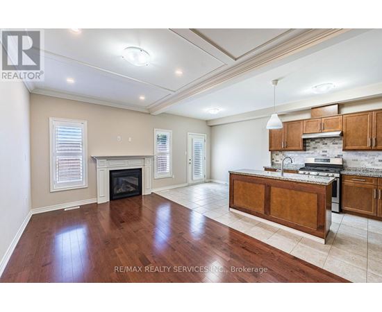 A spacious living room with hardwood floors and a fireplace.