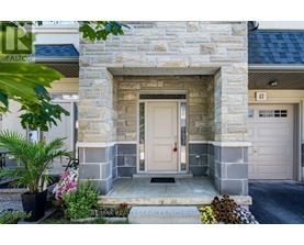 A stone building with a white door and a sign that says RE/MAX Realty Services Inc.