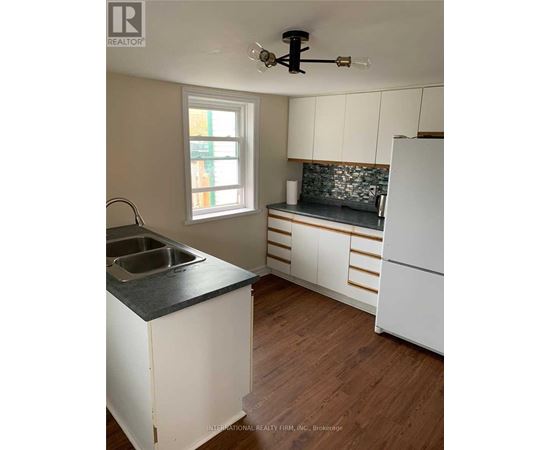 A kitchen with white cabinets and a black countertop.