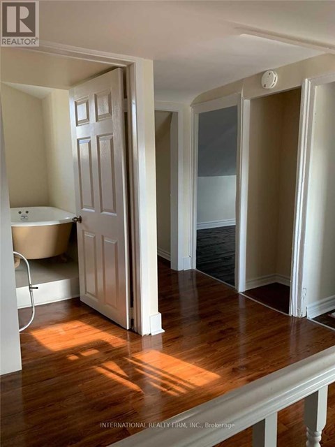 A bathroom with a tub and a doorway leading to another room.