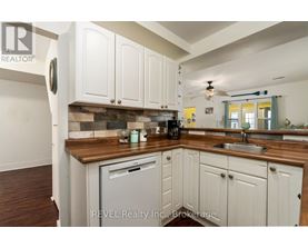 A kitchen with white cabinets and a wooden countertop.