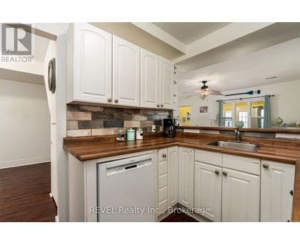 A kitchen with white cabinets and a wooden countertop.