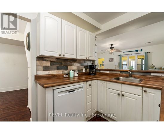 A kitchen with white cabinets and a wooden countertop.