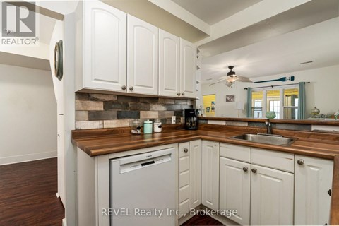 A kitchen with white cabinets and a wooden countertop.