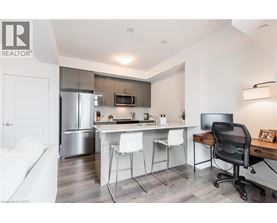 A modern kitchen with white chairs and a black office chair.