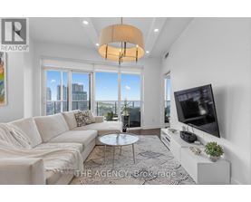 A living room with a white couch and a flat screen TV.