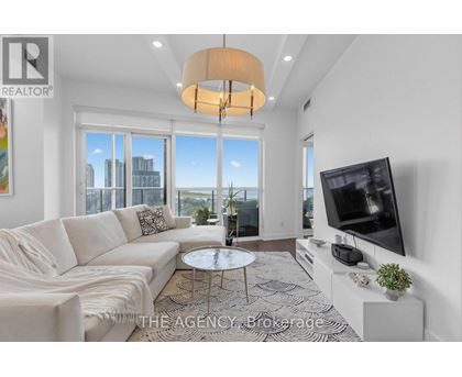 A living room with a white couch and a flat screen TV.