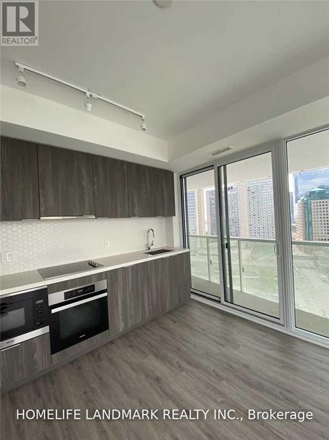 A kitchen with wooden cabinets and a microwave.