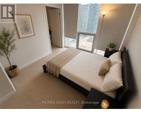 A bedroom with a large bed and a view of the city.