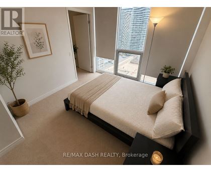 A bedroom with a large bed and a view of the city.
