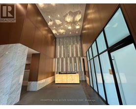 A large, modern room with a chandelier and a marble pillar.