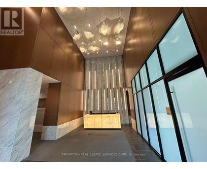 A large, modern room with a chandelier and a marble pillar.