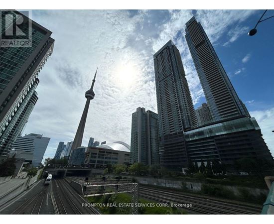 A cityscape with tall buildings and a highway in the foreground.