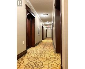 A hallway with a patterned floor and doors on either side.