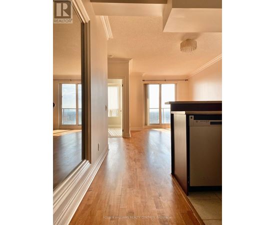 A real estate listing photo of a kitchen with wood floors and a stainless steel dishwasher.