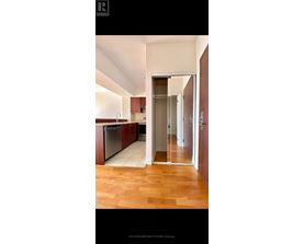 A kitchen with wooden floors and a refrigerator.