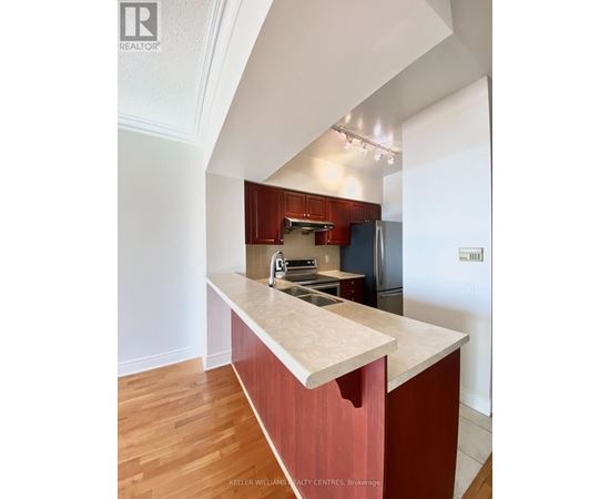 A kitchen with a marble counter top and wooden floors.