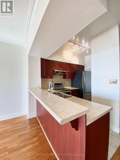A kitchen with a marble counter top and wooden floors.