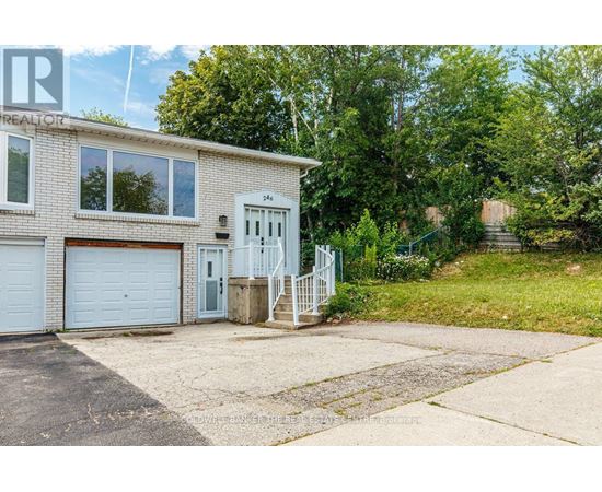 A house with a white garage door and a grey door is surrounded by greenery.