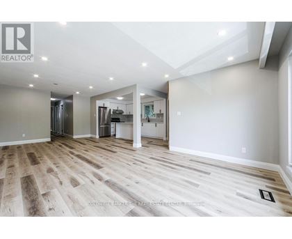 A white kitchen with wooden floors and white cabinets.