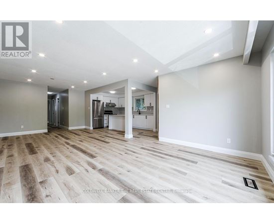 A white kitchen with wooden floors and white cabinets.