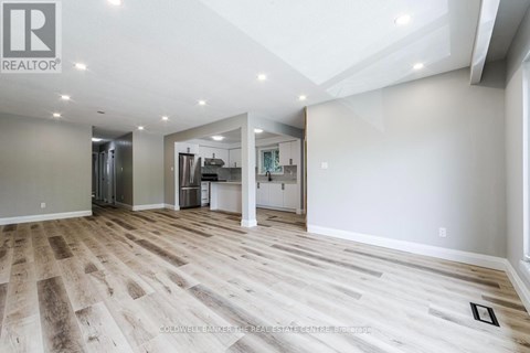 A white kitchen with wooden floors and white cabinets.