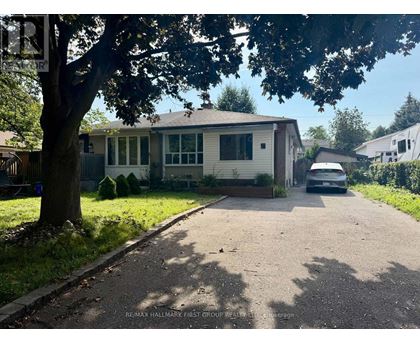 A residential house with a car parked in front.