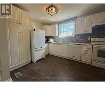 A kitchen with white appliances and cabinets.