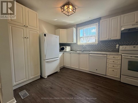 A kitchen with white appliances and cabinets.