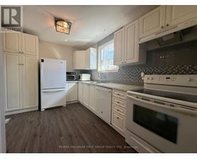 A kitchen with white appliances and wooden floors.