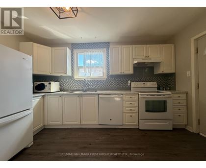 A kitchen with white appliances and cabinets.