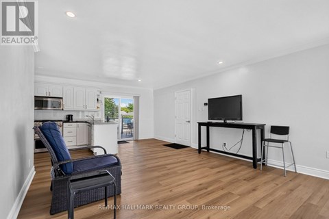 A spacious living room with a television and a chair.